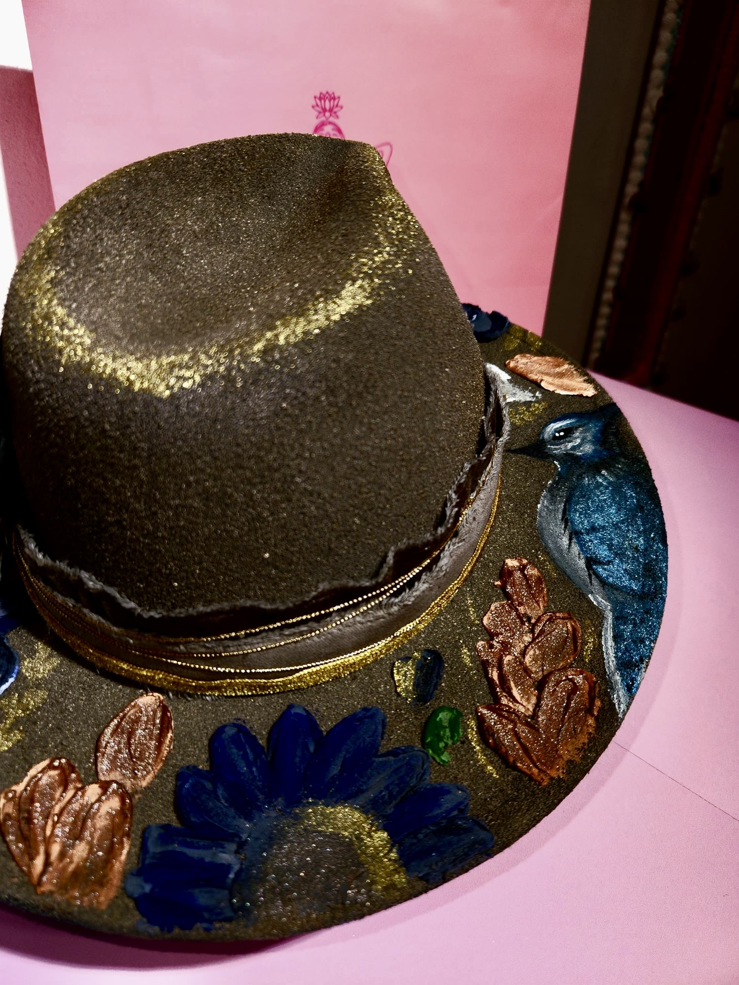Detalle de sombrero oscuro con flores y acabado dorado